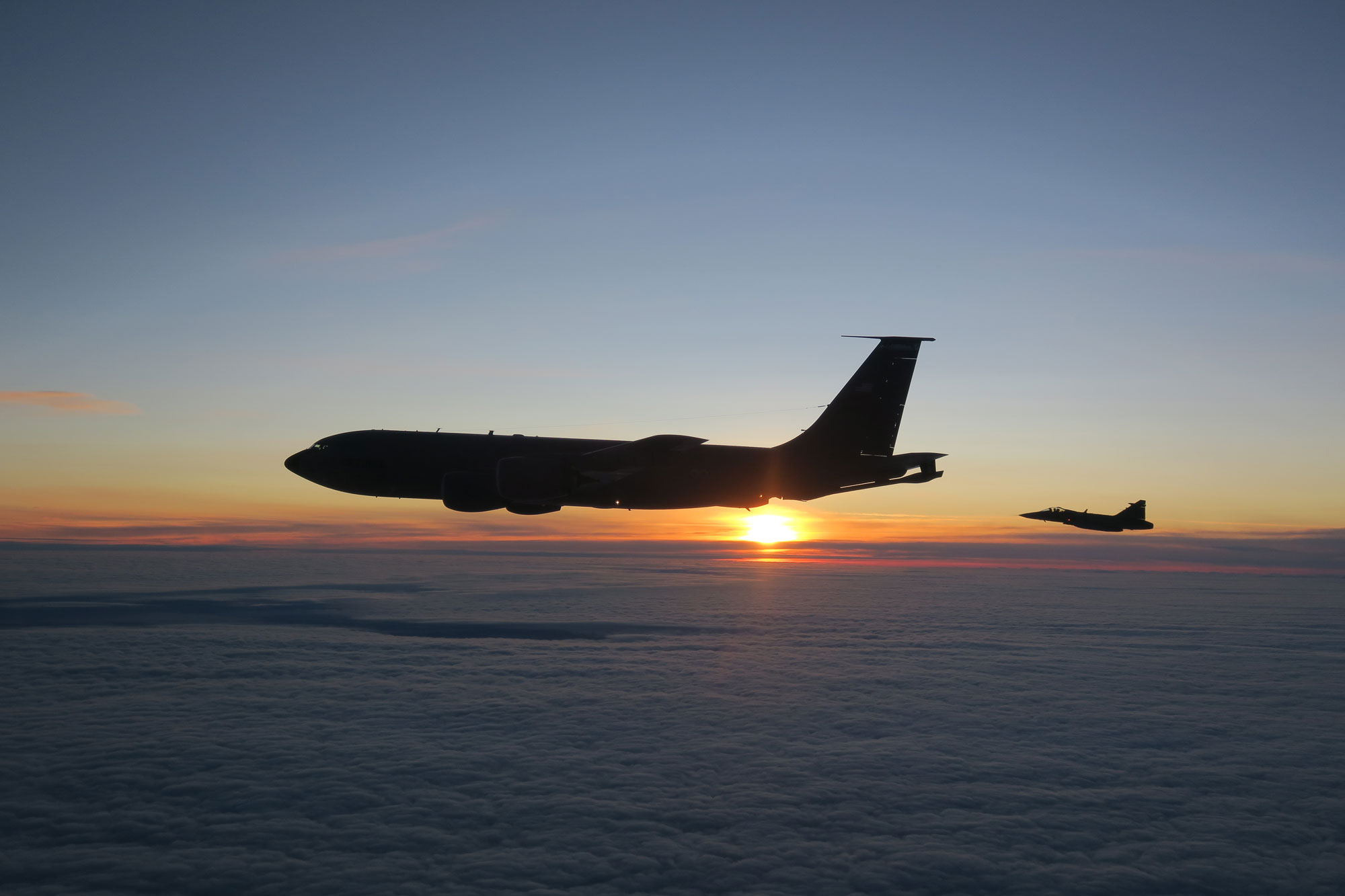 Två flygplan som genomför lufttankningsprov i mörker, det amerikanska flygvapnets tankerflygplan Boeing KC135 Stratotanker och JAS 39 C/D Gripen.