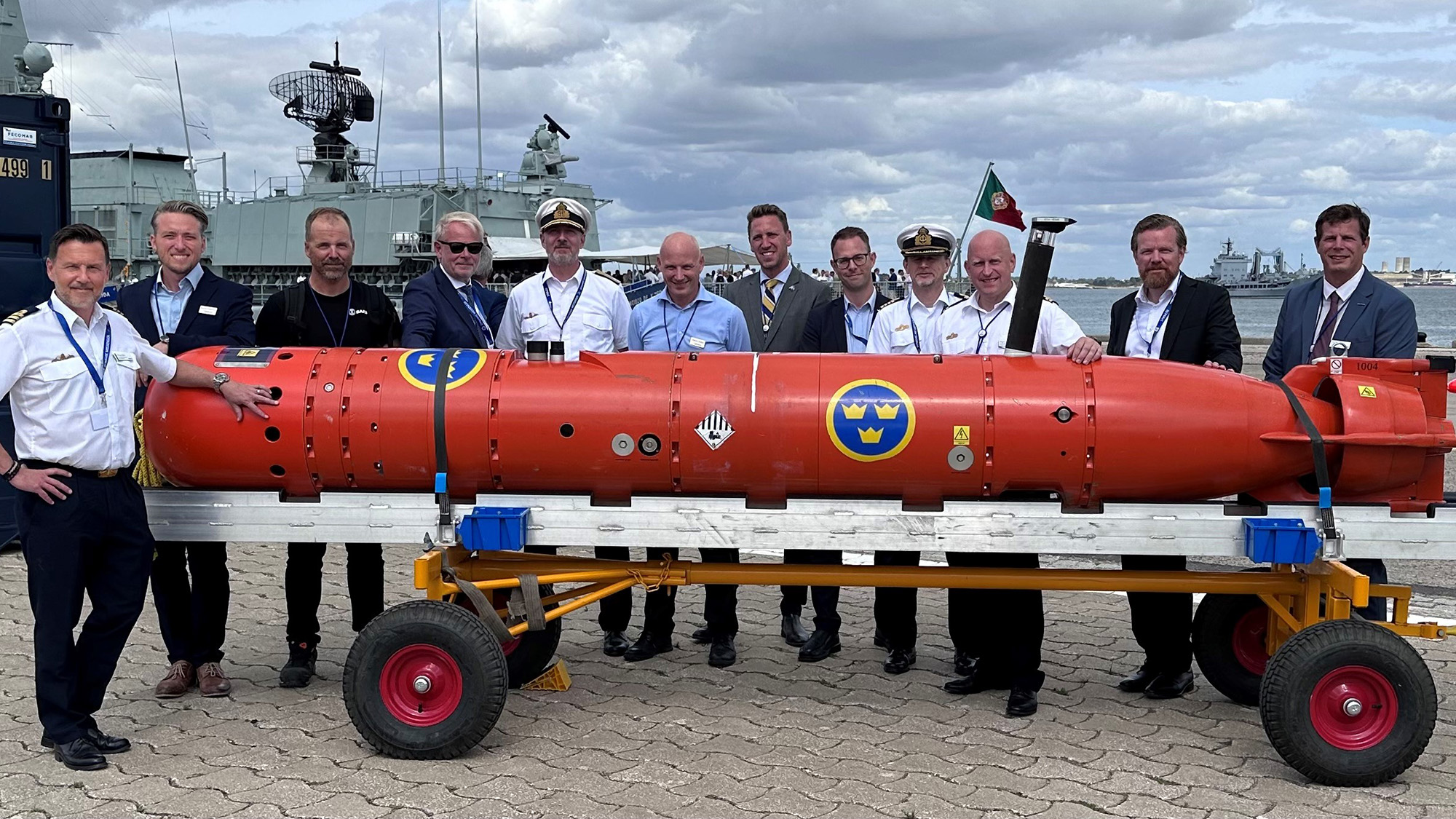 Ett stort antal personer står samlade runt en orange AUV.