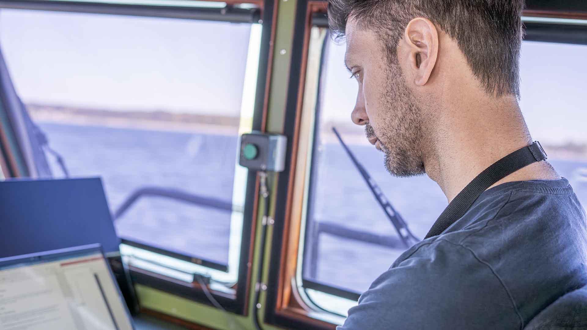 Albert Löfgren, provledare på FMV: verksamhetsområde test och evaluering marin, i styrhytten på trupptransportbåten. Under proverna till sjöss kontrollerar och verifierar man alla system gentemot kravställningen. Foto: FMV