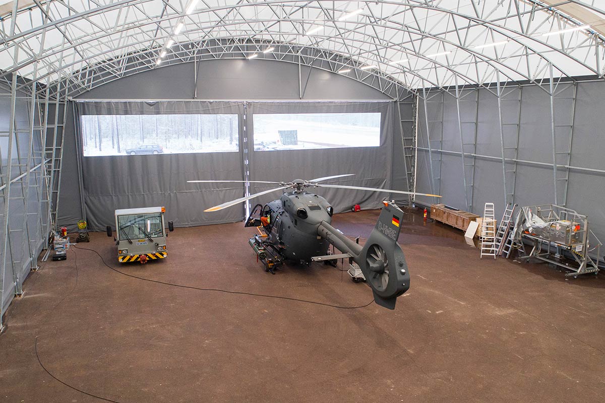 A helicopter inside a  tent hangar