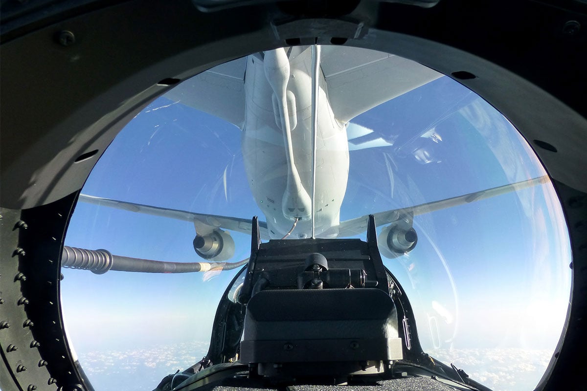 Fighter aircraft connected to air tanker, in the air