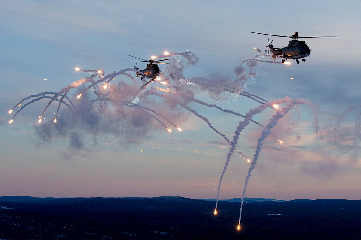 Helicopters in the air ejecting flares over Vidsel Test Range